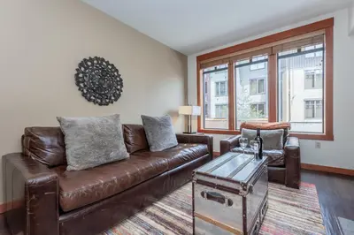 a living room with a brown leather couch and a table at Village 3211 in Mammoth Lakes
