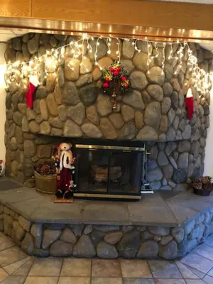 a stone fireplace with christmas decorations on a stone wall at Shilo Inn Mammoth Lakes in Mammoth Lakes