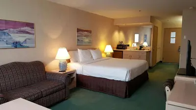 a hotel room with a bed and a chair at Shilo Inn Mammoth Lakes in Mammoth Lakes