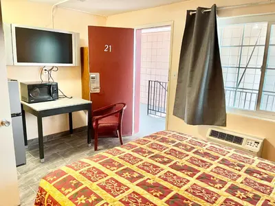 a bedroom with a bed and a desk with a computer at Royal Lodge in Coalinga