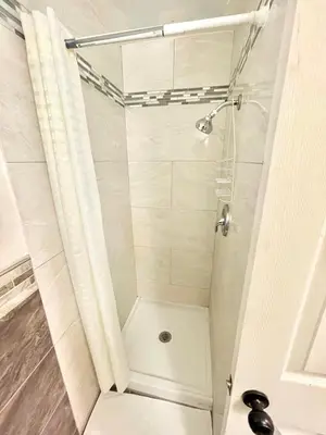 a shower with a glass door in a bathroom at Royal Lodge in Coalinga