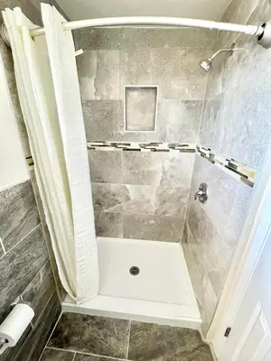a bathroom with a shower with a tub at Royal Lodge in Coalinga