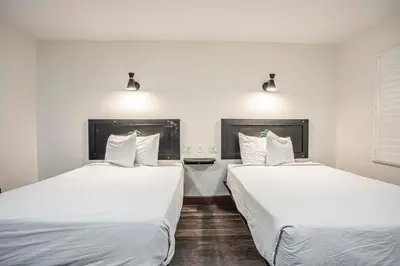 two beds sitting next to each other in a room at The Greens Hotel on Stockton in Sacramento
