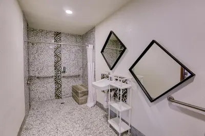a bathroom with a sink and a mirror at The Greens Hotel on Stockton in Sacramento