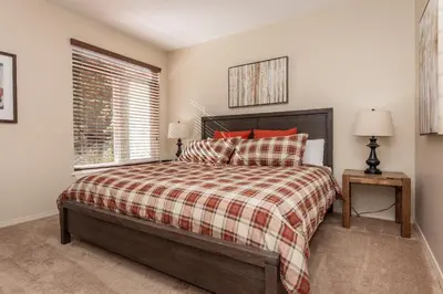 a bedroom with a bed with red pillows and a window at Silver Bear #19 Condo in Mammoth Lakes