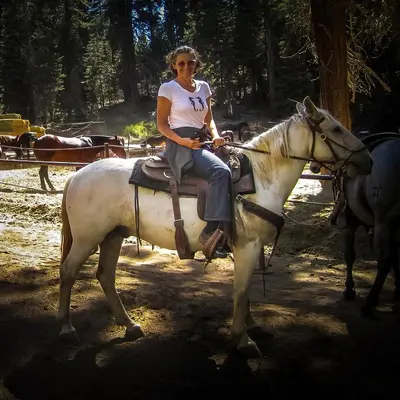 a woman is sitting on a white horse at Rio Sierra Riverhouse in Three Rivers
