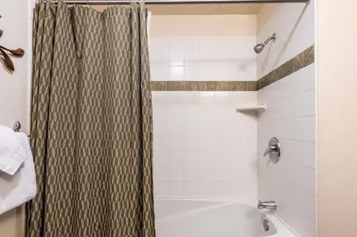 a bathroom with a shower and a white tub at Village # 3310 - Lincoln House in Mammoth Lakes