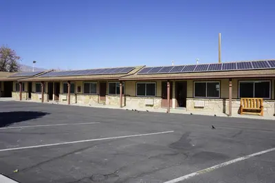 an empty parking lot in front of a building with solar panels at Bristlecone Motel in Big Pine