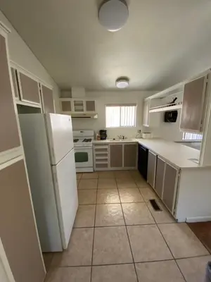 a kitchen with white cabinets and a white refrigerator at Bristlecone Motel in Big Pine