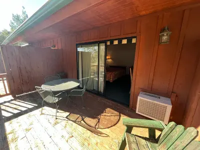 a screened in porch of a house with a table and chairs at Whispering Pines Lodge in Kernville