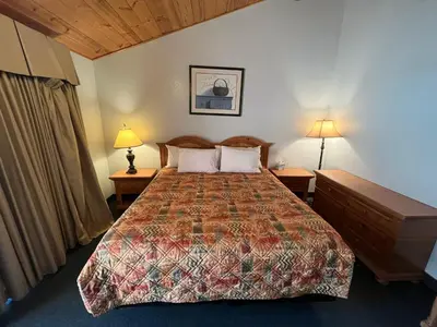 a bedroom with a bed with two tables and two lamps at Whispering Pines Lodge in Kernville