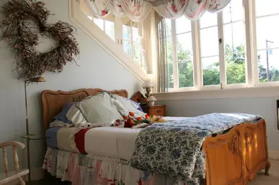 a bedroom with a bed with areath on the wall and windows at Eureka Street Inn in Sutter Creek
