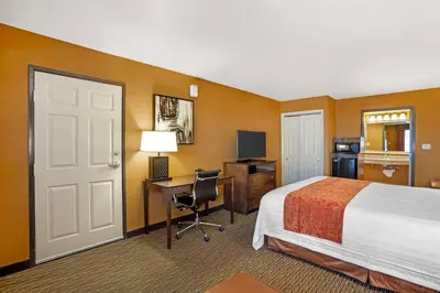 a hotel room with a bed and a desk with a computer at Best Western Exeter Inn & Suites in Exeter