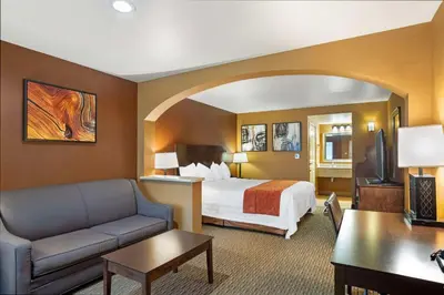 a hotel room with a bed and a couch at Best Western Exeter Inn & Suites in Exeter