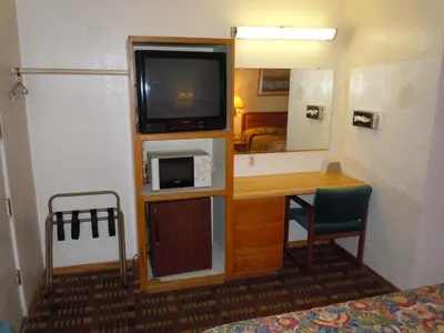 a room with a tv and a desk with a microwave at Value Inn in Fallon