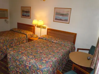 a hotel room with two beds and a table at Value Inn in Fallon