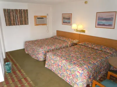 a hotel room with two beds and a table at Value Inn in Fallon