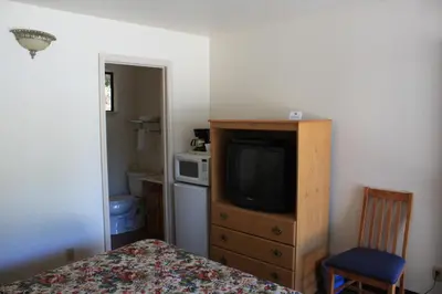 a bedroom with a bed and a tv on a dresser at Mother Lode Motel in Placerville