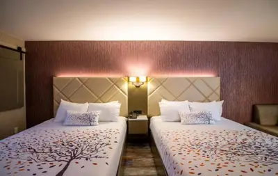 a hotel room with two beds and a chair at Empeiria High Sierra Hotel in Mammoth Lakes