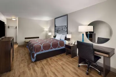 a hotel room with a bed and a desk at Super 8 by Wyndham Fallon in Fallon