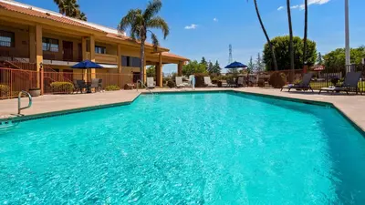 a swimming pool in front of a hotel at Best Western Apricot Inn in Chaney Ranch