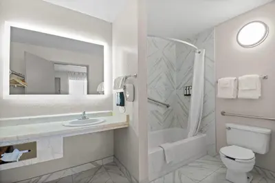 a bathroom with a sink and a toilet and a mirror at Days Inn by Wyndham Lost Hills in Lost Hills