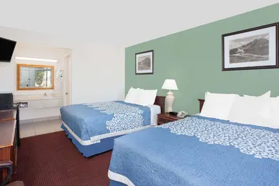 a hotel room with two beds and a bathroom at Days Inn by Wyndham Lost Hills in Lost Hills