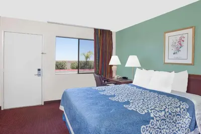 a hotel room with a bed and a large window at Days Inn by Wyndham Lost Hills in Lost Hills