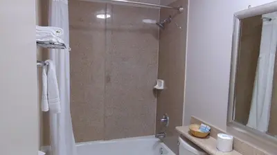 a bathroom with a shower with a glass door at Corcoran Country Inn in Corcoran
