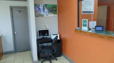 a office with a chair and a computer on a desk at Corcoran Country Inn in Corcoran