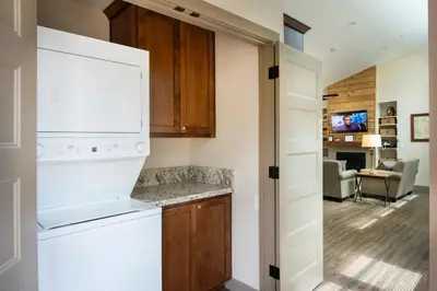 a kitchen with a white refrigerator and a living room at 11R Spring Meadow Retreat in Wawona