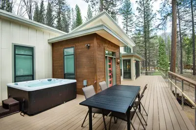 a deck with a hot tub and a table and chairs at 11R Spring Meadow Retreat in Wawona