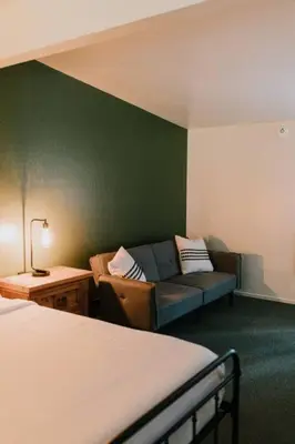 a hotel room with a couch and a bed at The Long Barn Lodge in Long Barn