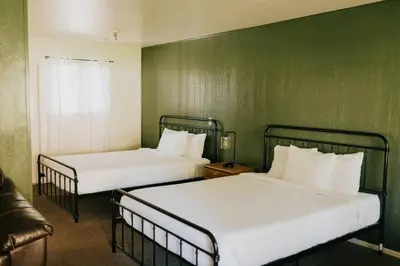 two beds in a room with green walls at The Long Barn Lodge in Long Barn