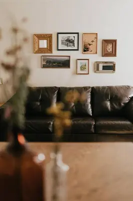 a black couch in a living room with pictures on the wall at The Long Barn Lodge in Long Barn