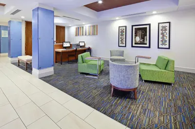a waiting room with green chairs and a desk at Holiday Inn Express & Suites Clovis Fresno Area by IHG in Clovis