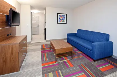 a living room with a blue couch and a tv at Holiday Inn Express & Suites Clovis Fresno Area by IHG in Clovis
