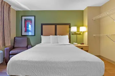 a bedroom with a large bed and a chair at Extended Stay America Suites - Stockton - March Lane in Stockton