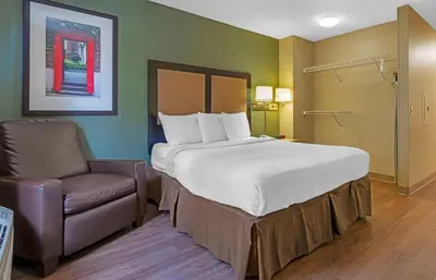 a bedroom with a large bed and a chair at Extended Stay America Suites - Stockton - March Lane in Stockton