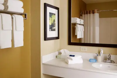 a bathroom with a sink and a mirror and towels at Extended Stay America Suites - Stockton - March Lane in Stockton