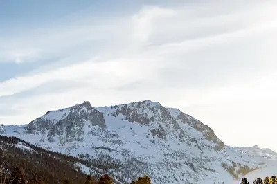a mountain covered in snow on a cloudy day at Heidelberg Inn & Resort in June Lake