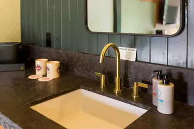 a kitchen sink with two cups and a mirror at Station House Inn South Lake Tahoe in South Lake Tahoe