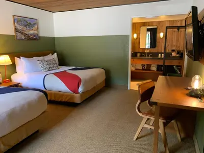 a hotel room with two beds and a desk at Station House Inn South Lake Tahoe in South Lake Tahoe