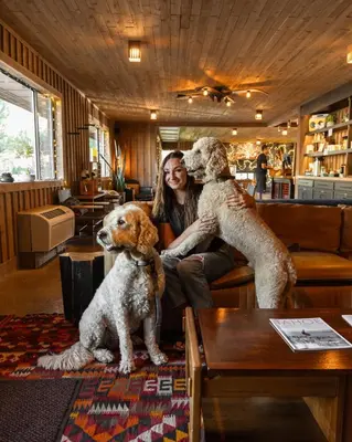 a woman sitting on a couch with two dogs at Station House Inn South Lake Tahoe in South Lake Tahoe