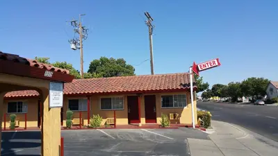 a building with a street sign in front of it at Slumber Motel in Merced