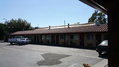 a building with a truck parked in front of it at Slumber Motel in Merced