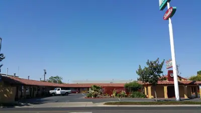 an empty parking lot in front of a motel at Slumber Motel in Merced