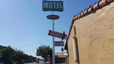 a motel sign on the side of a building at Slumber Motel in Merced