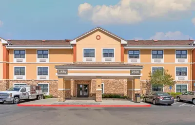 a large orange building with cars parked in a parking lot at Extended Stay America Suites - Stockton - Tracy in Tracy