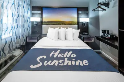 a hotel room with a bed with a hello sunshine sign on it at Days Inn by Wyndham Galt - Elk Grove South in Galt